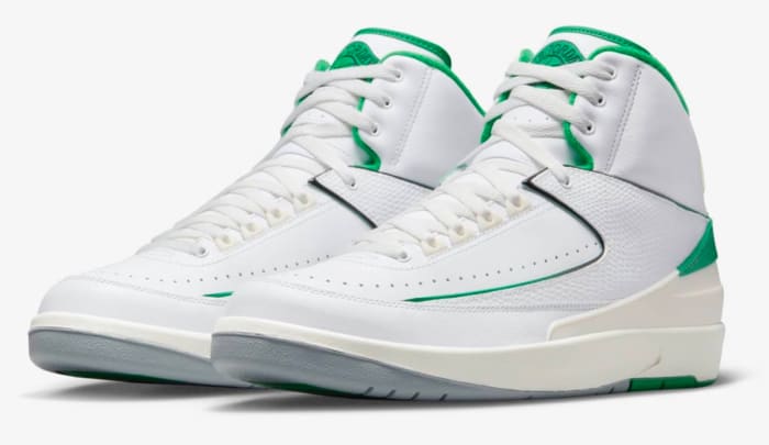 View of white and green Air Jordan shoes.